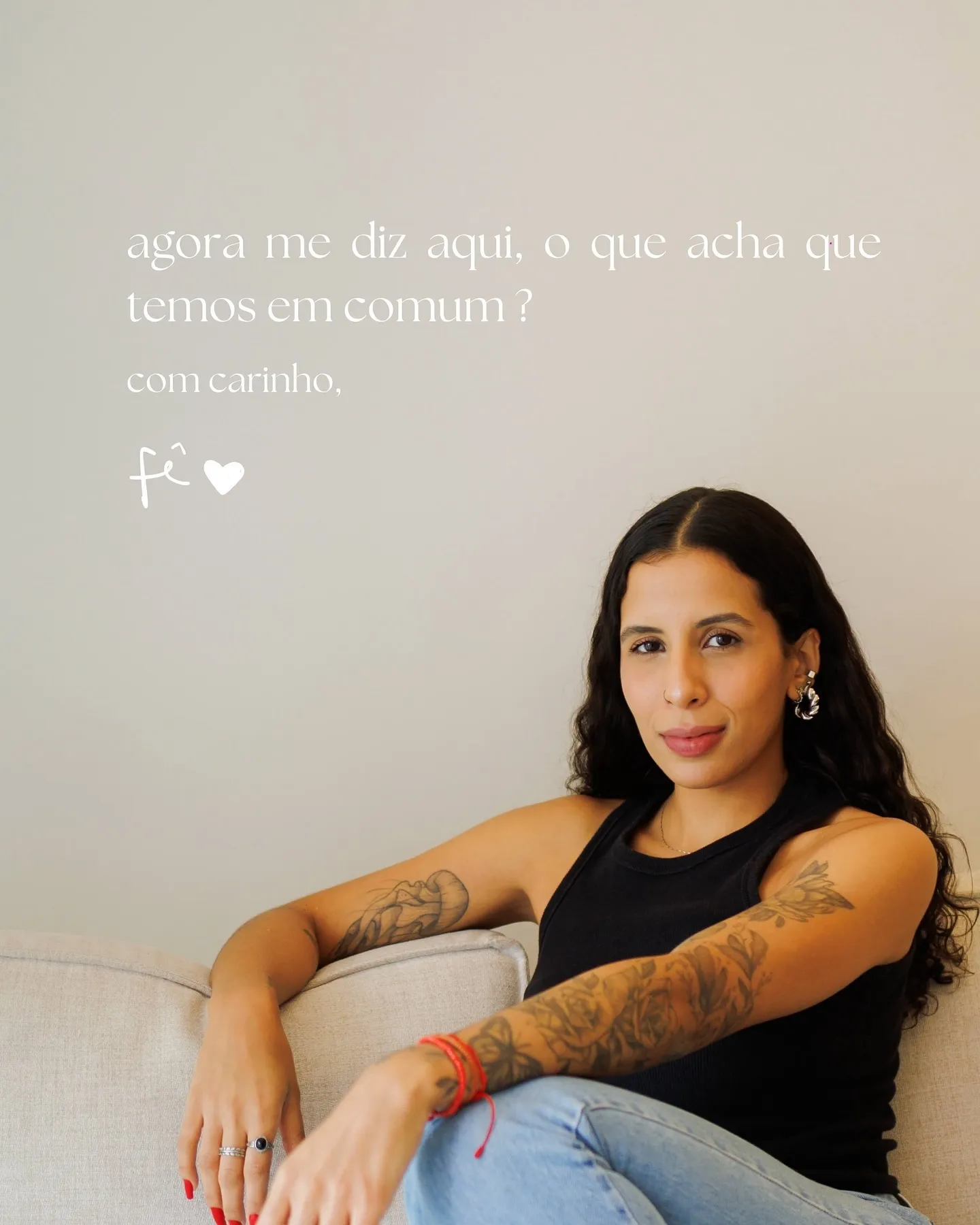 Fernanda Aguiar sentada num sofá claro, com a assinatura manuscrita “fê” na foto