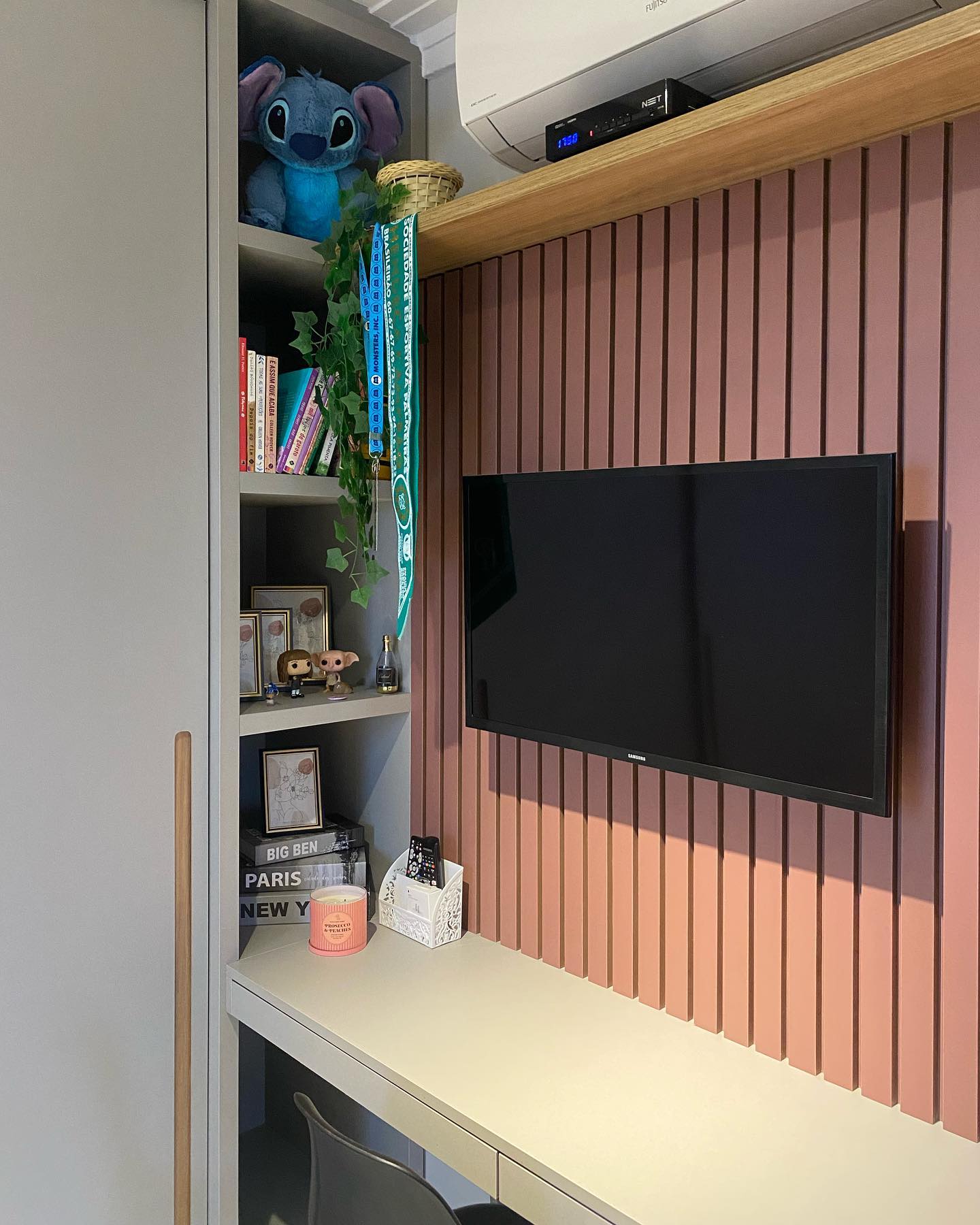 Quarto da Isa: painel ripado rosa com TV, marcenaria clara e prateleiras decoradas
